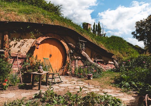 Explore a cozy hobbit house nestled in New Zealand's lush countryside, perfect for a rustic getaway.